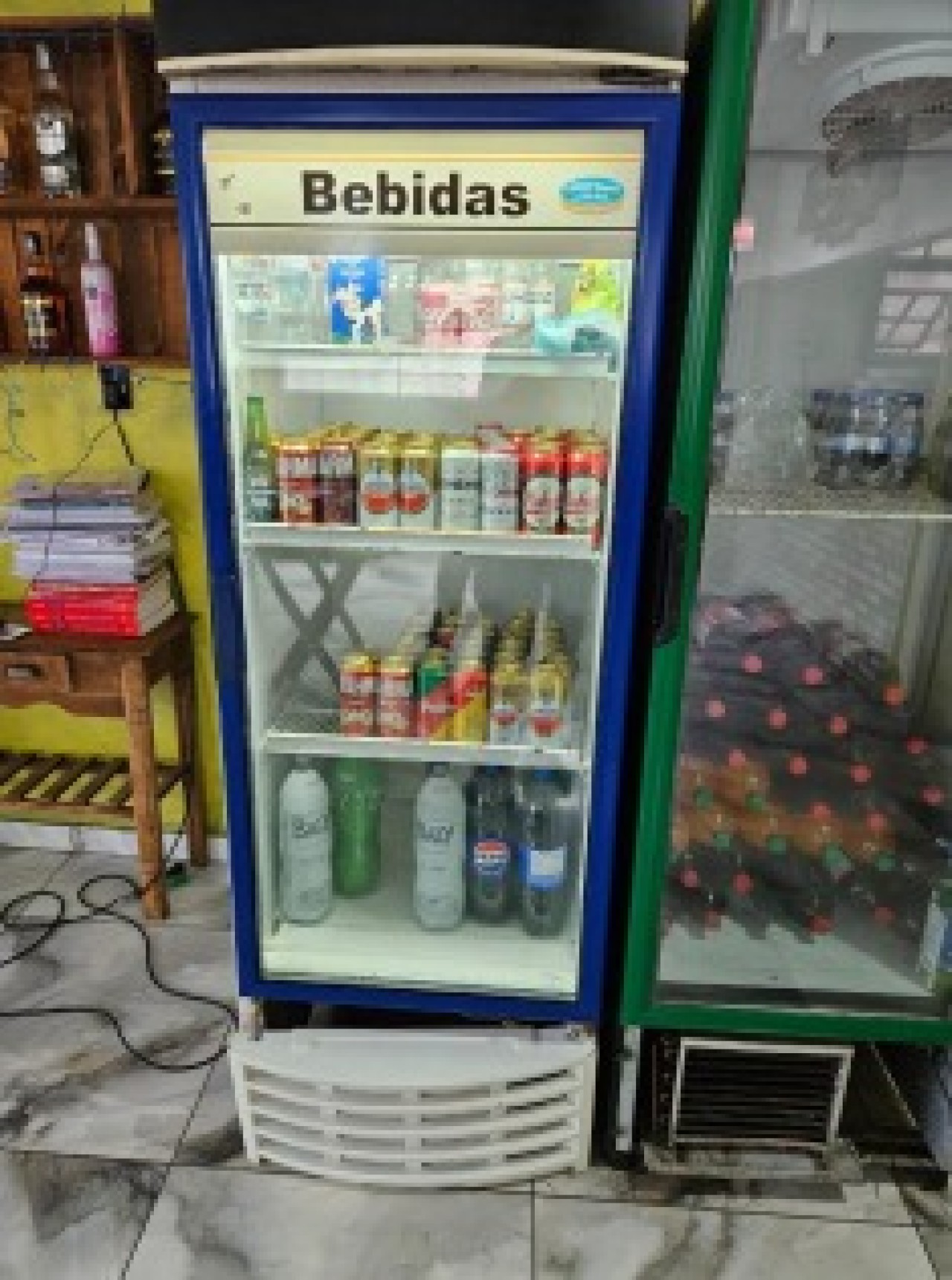 UM FREEZER CERVEJEIRO, SEM MARCA APARENTE, DANIFICADO, APARENTEMENTE SEM CONDIÇÕES DE FUNCIONAMENTO, COM BORDA AZUL — leilão